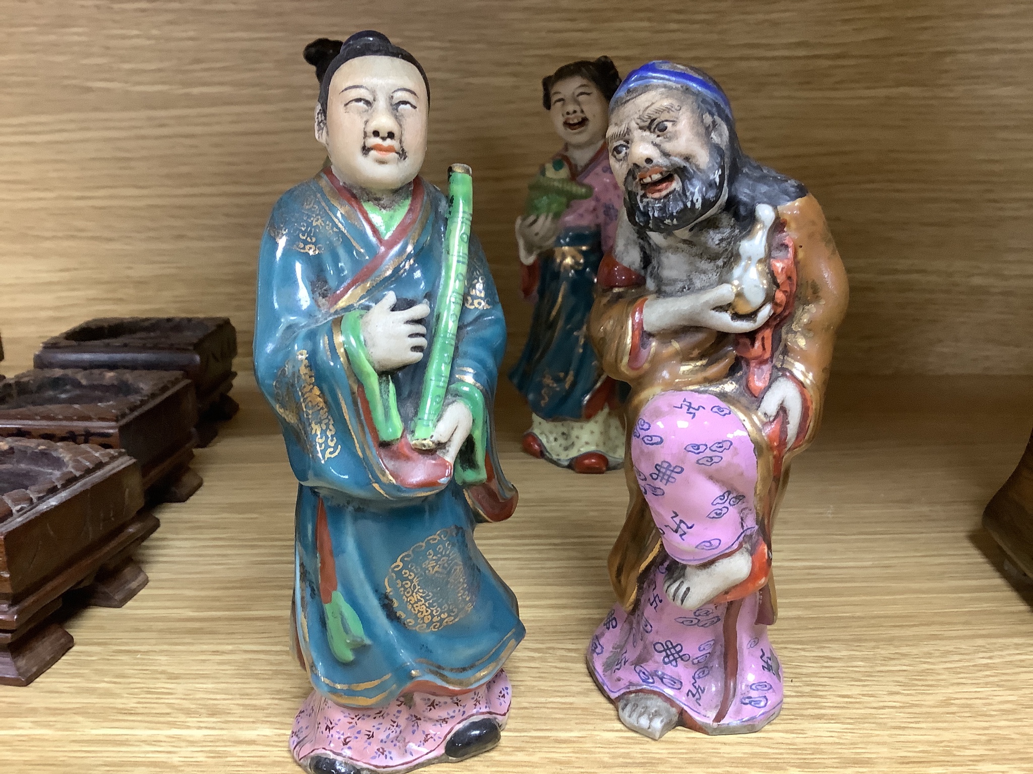 A set of eight 20th century Chinese porcelain figures of immortals, 15cm, each on carved wood stand